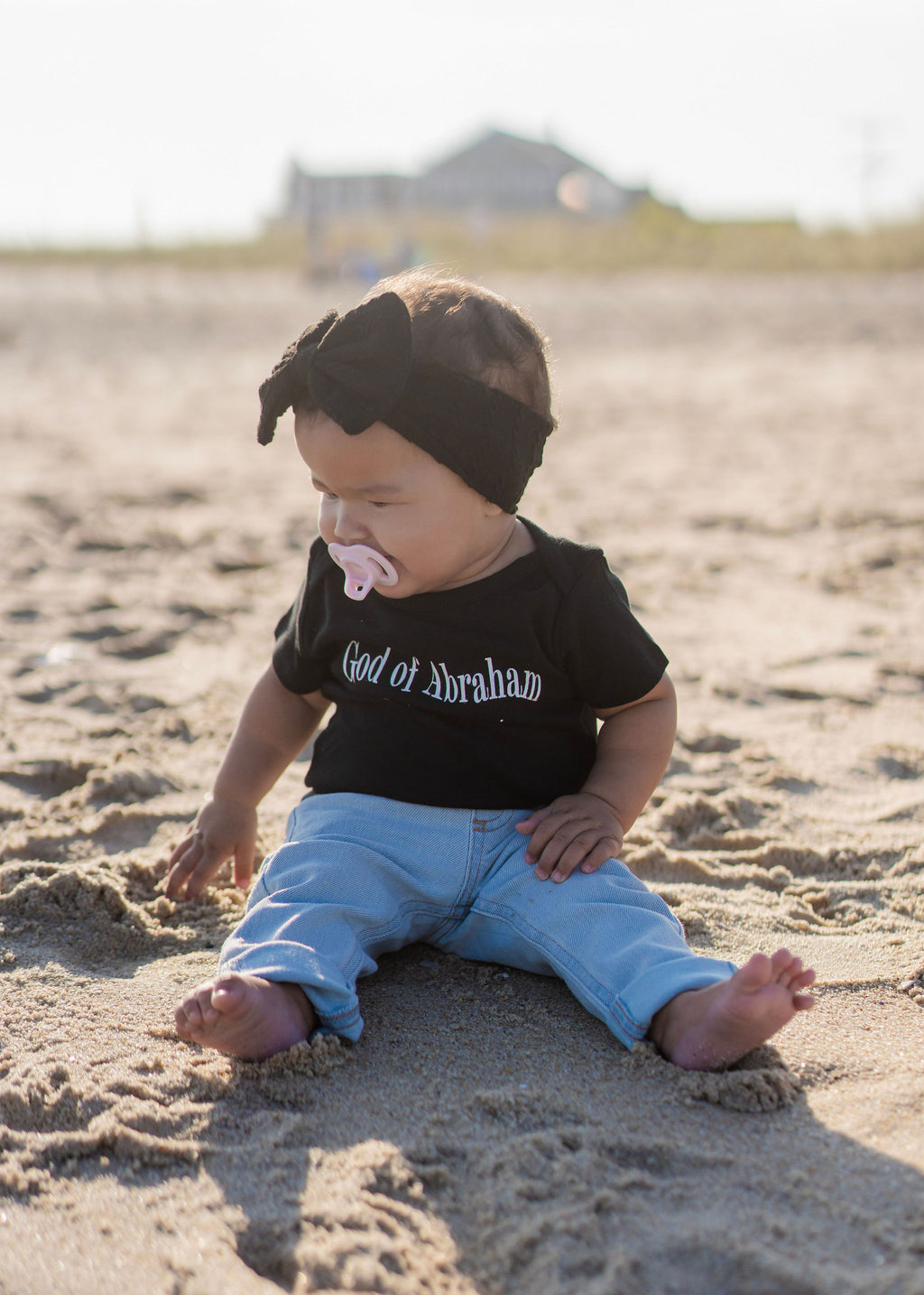 Christian baby wearing black onesie organic cotton bodysuit