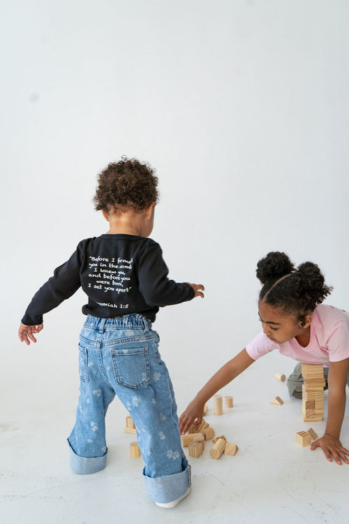 Black organic baby onesie featuring "Before I Formed You" from Jeremiah 1:5, reminding every child they are known by God and created with purpose.