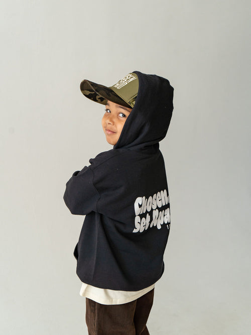 Youth wearing a black Chosen & Set Apart Christian hoodie, reminding children they are chosen by God and set apart with purpose.